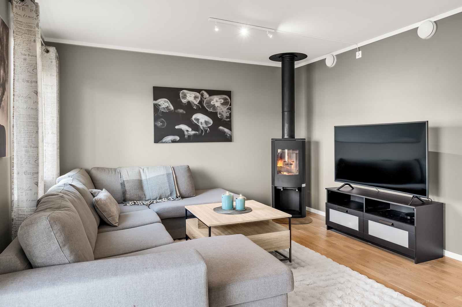 Frittstående peisovn i hjørne med glassplate på gulv Galleribilde