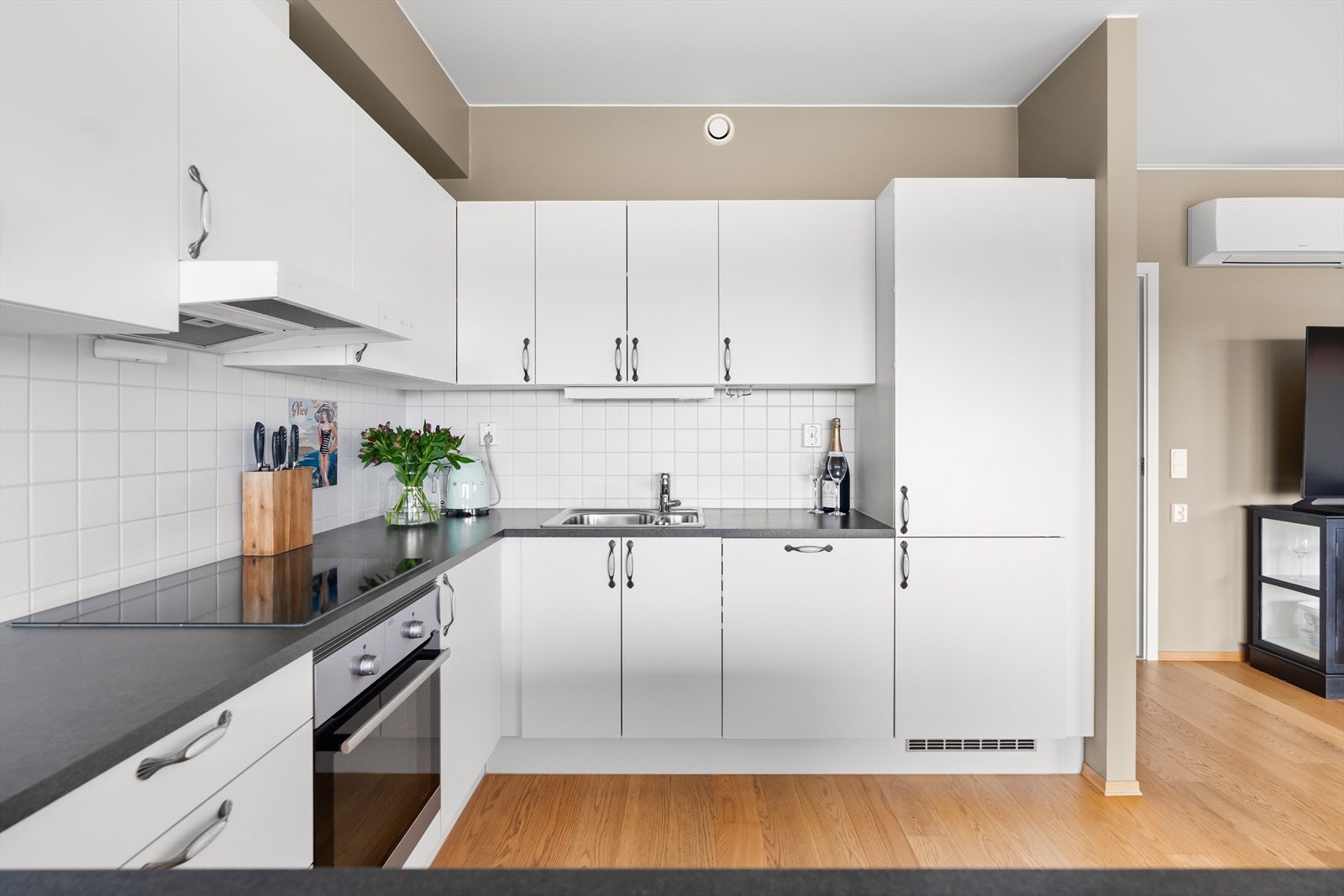 Det er satt opp fliser på veggen mellom benkeplate og overskap. Galleribilde