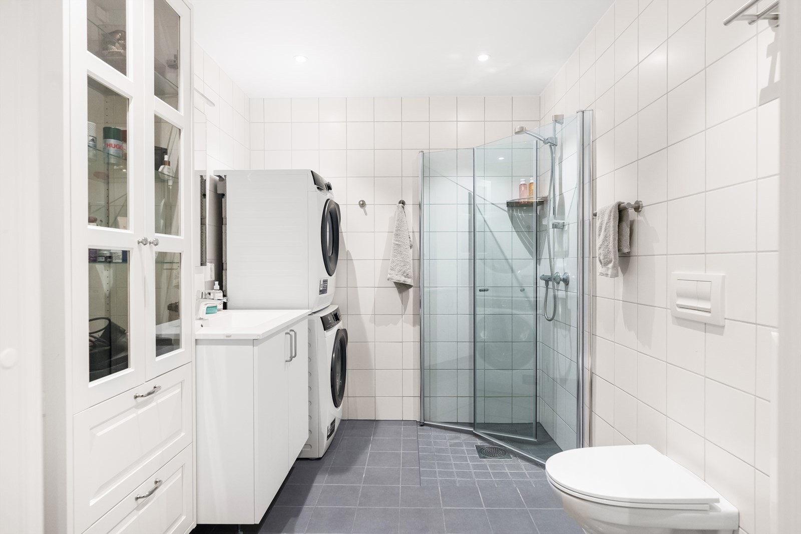 Badet er utstyrt med dusjhjørne, servantskap, veggmontert wc, opplegg for vaskemaskin, rørfordelingsskap og mekanisk avtrekk. I tillegg er det gulvvarme. Galleribilde