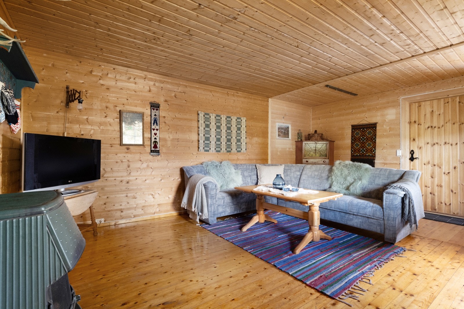 Gulvene består av klassiske heltregulv, og både vegger og himlinger har gjennomgående overflater i trepanel, noe som skaper en lun og tradisjonell hyttefølelse. Galleribilde