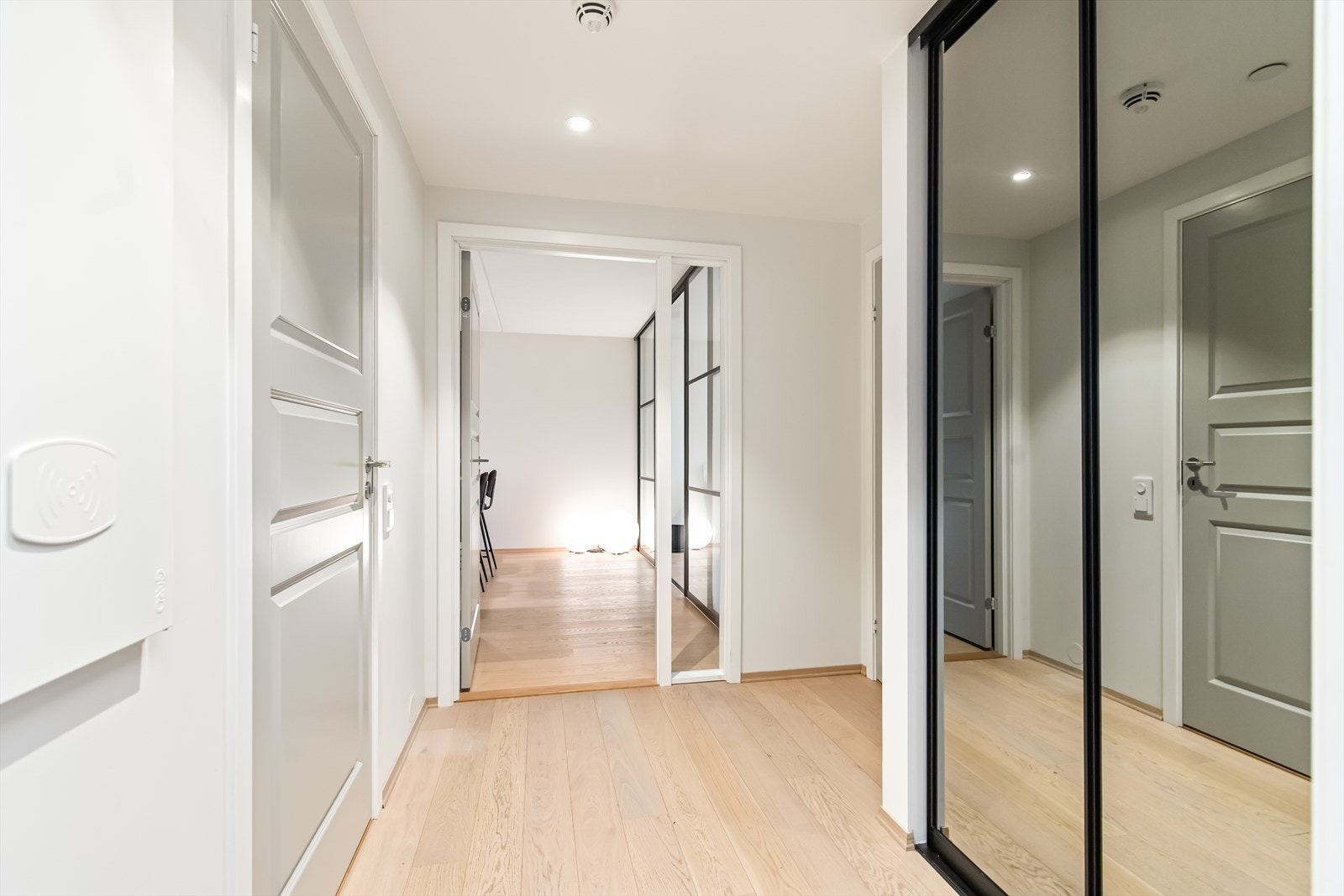 Entréen fremstår lys og innbydende, med malte vegger og parkettgulv som gir et moderne uttrykk. Galleribilde