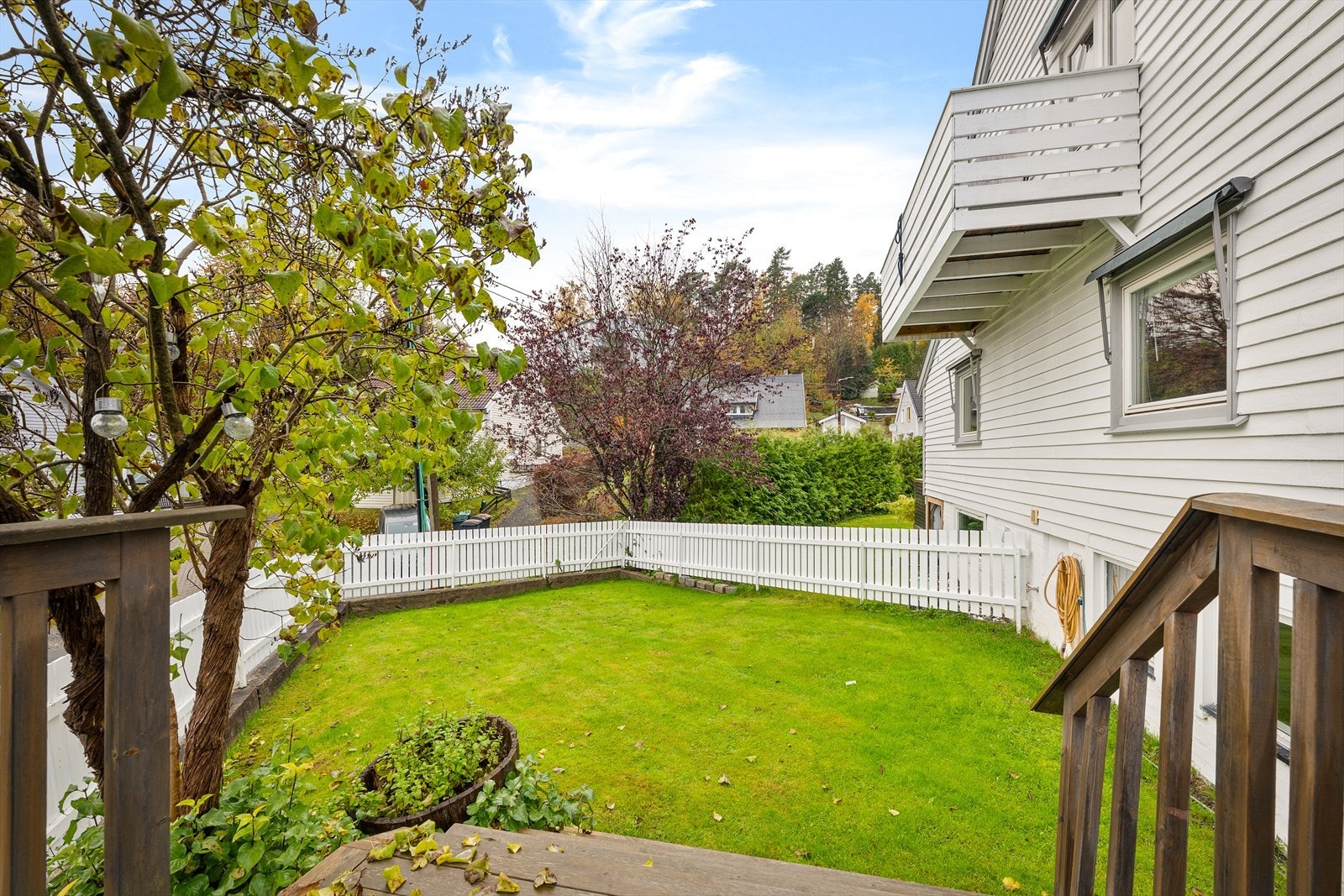 Hagen er pent opparbeidet med gressplen, trær og diverse beplantning Galleribilde