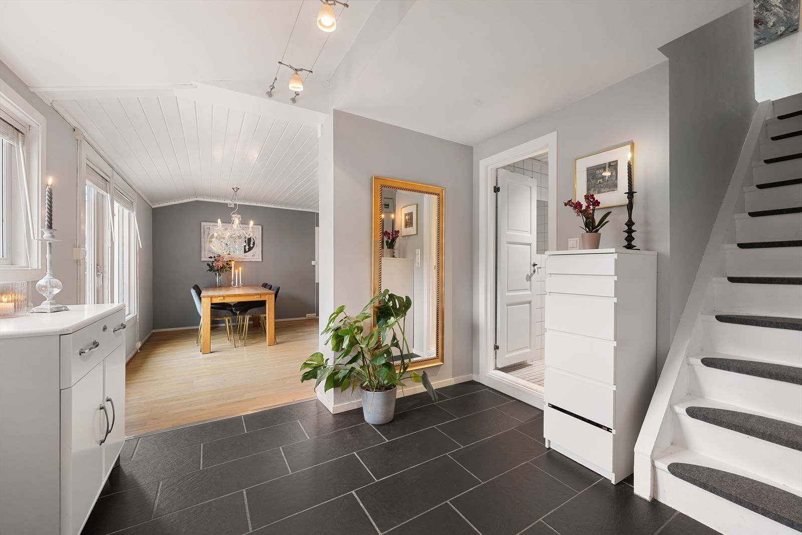 Lys og innbydende entré med flislagt gulv og plass til oppheng av yttertøy og sko Galleribilde