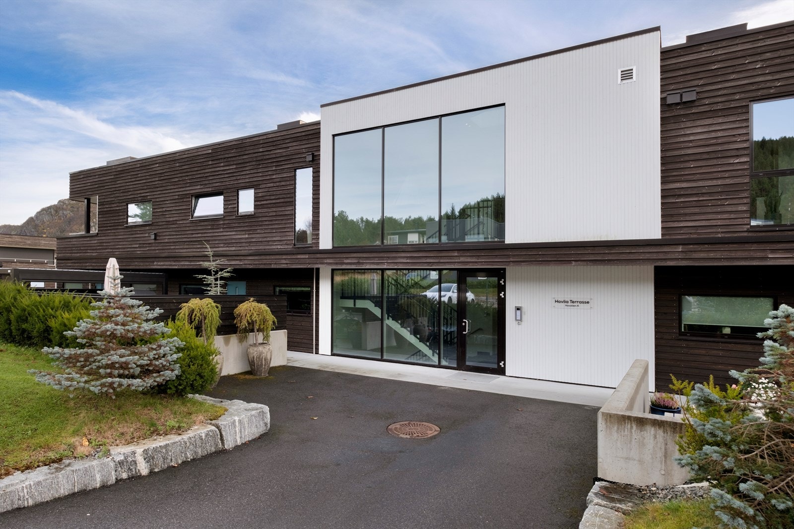 Leiligheten har en moderne fasade med store vindusflater og inngang mot nord i aluminium, som gir et stilfullt preg Galleribilde