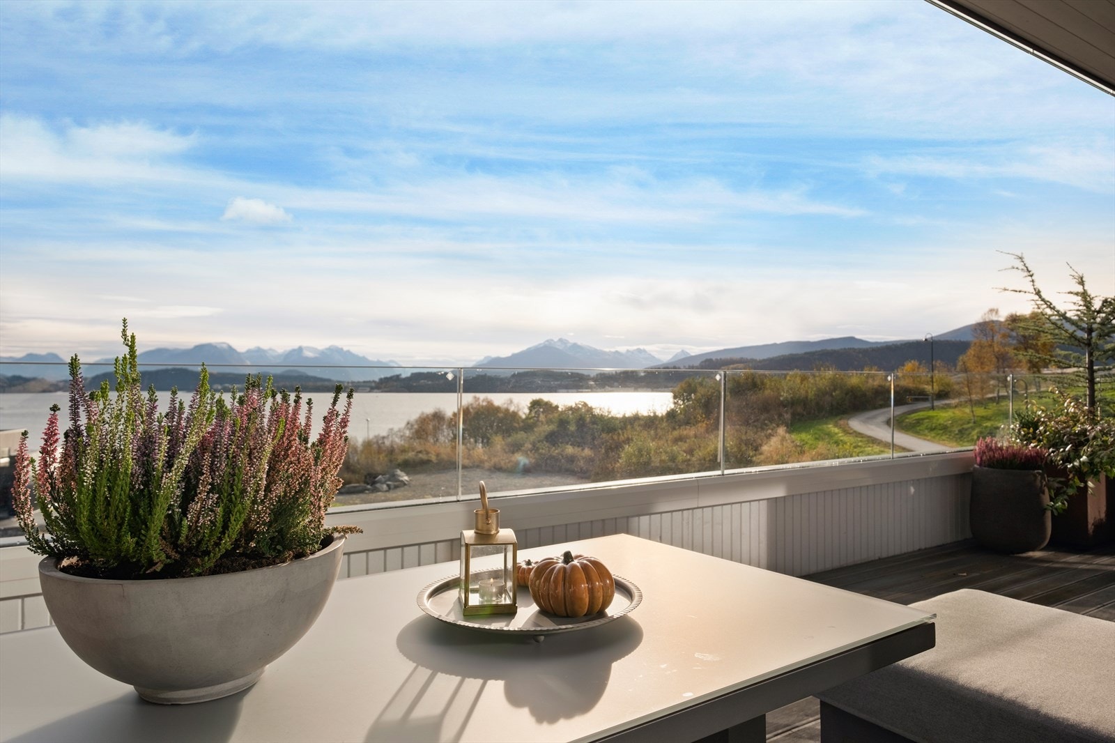 Utsikten fra terrassen strekker seg over fjorden, med fjell i bakgrunnen som gir en naturskjønn opplevelse. Galleribilde