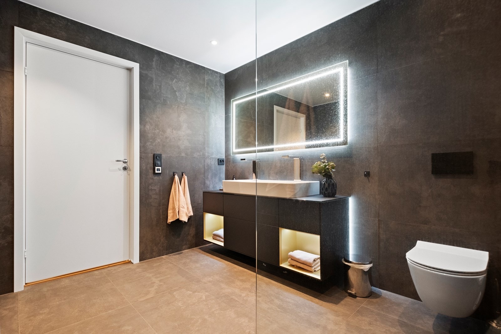 Det er valgt moderne farger på badet samt store og flotte fliser båder på gulv og vegger Galleribilde