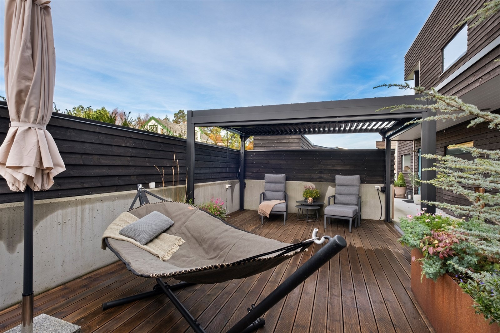 Uteplassen er utstyrt med en pergola og har treterrassebord, som gir et komfortabelt og skjermet område. Galleribilde