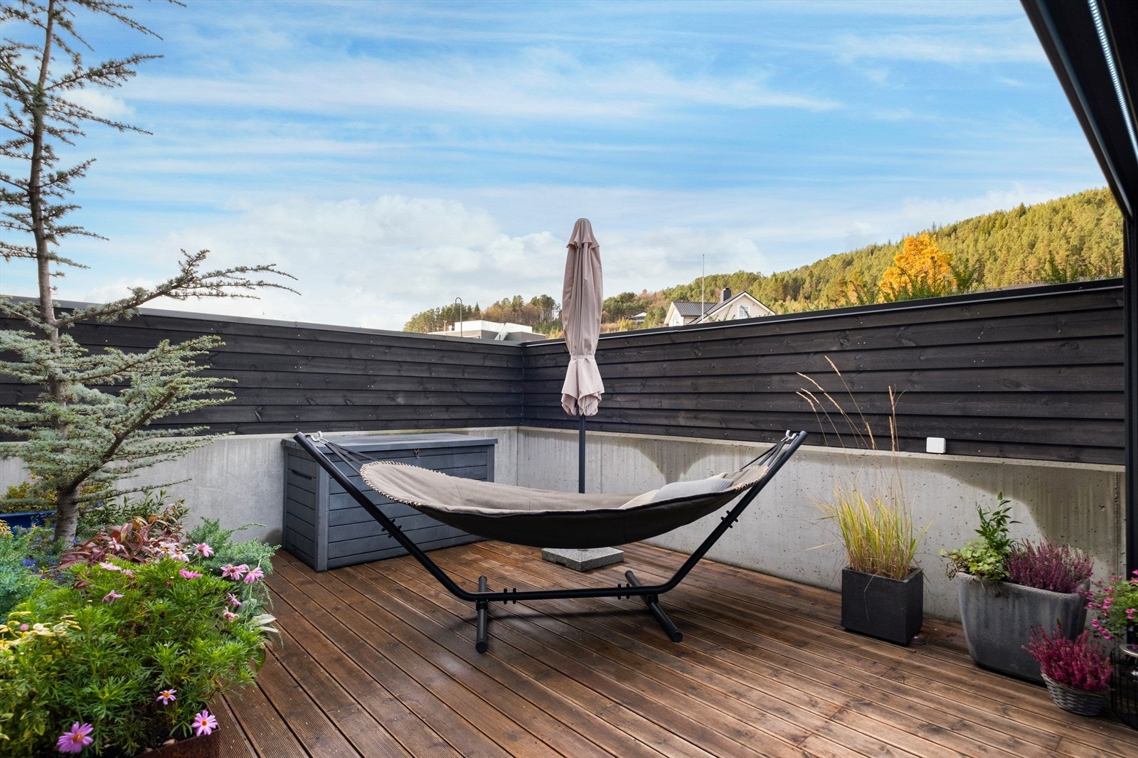 Den nordvestvendte uteplassen har levegger av betong og treverk, som gir et skjermet område Galleribilde