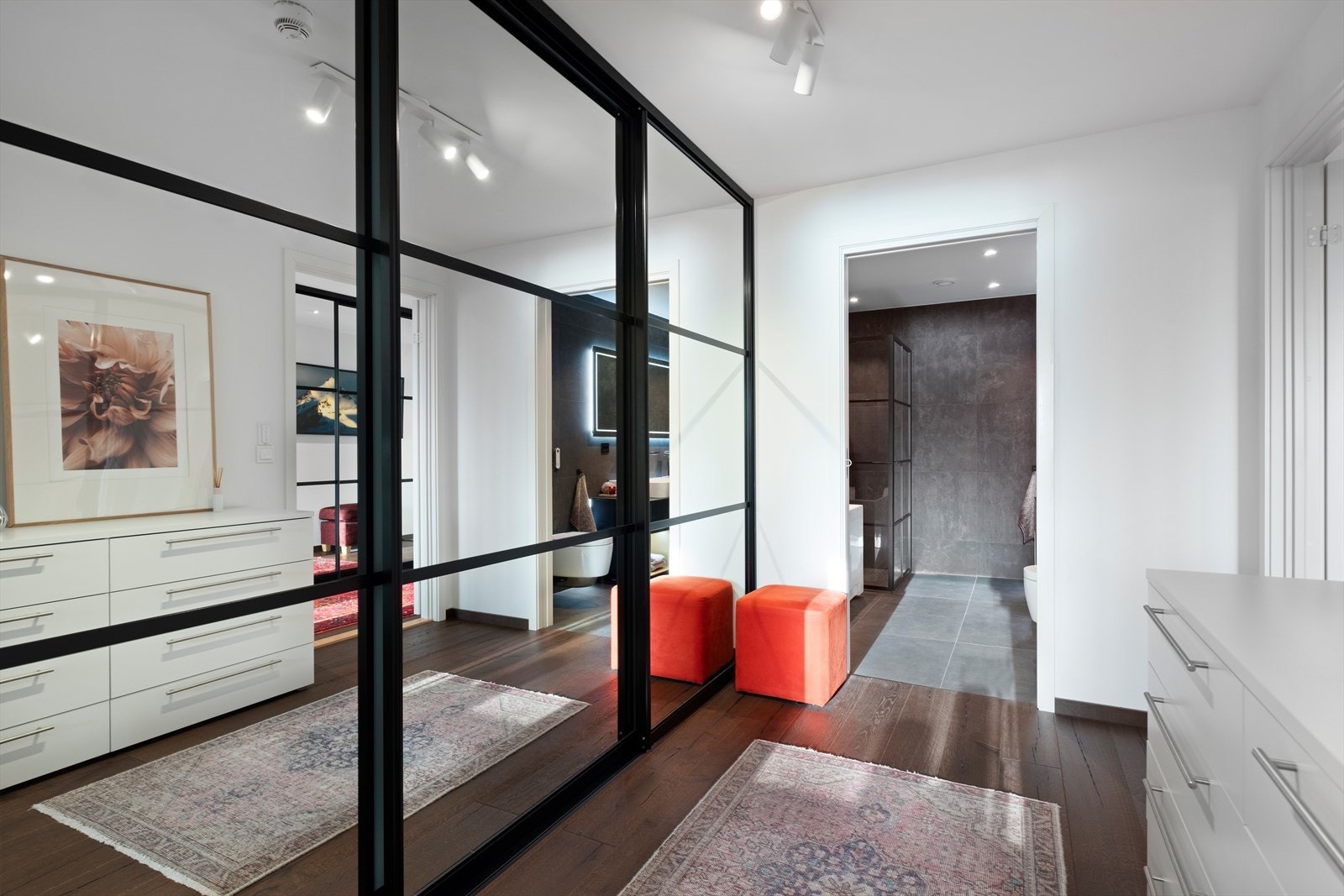 Skyvedørsgarderoben gir effektiv oppbevaring og speiler rommet, mens parkettgulvet gir en varm tone. Galleribilde