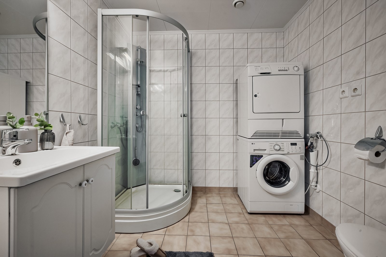 Badet er praktisk innredet med fliser på gulv og vegger, og har deilige varmekabler i gulvet. Galleribilde