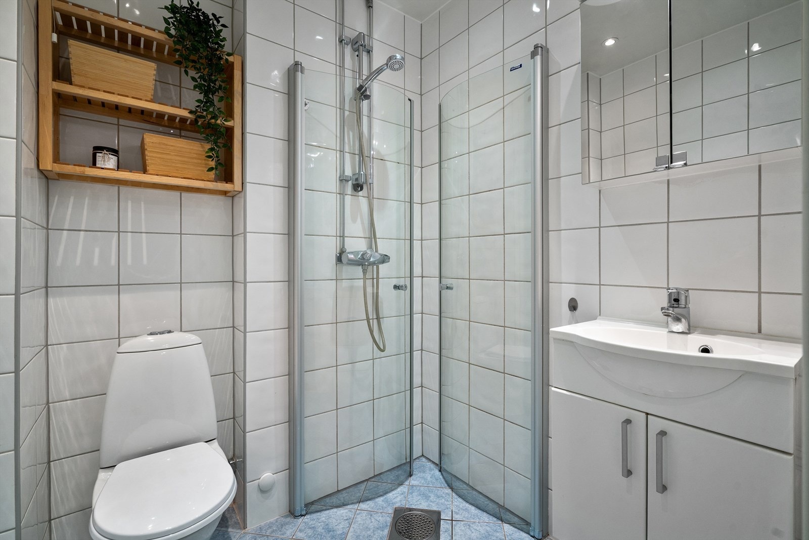 Flislagt bad med varmekabler i gulv, downlights i himling, dusjhjørne med glassdører, speilskap, toalett og servantskap. Pusset opp i regi borettslaget i 2005. Galleribilde