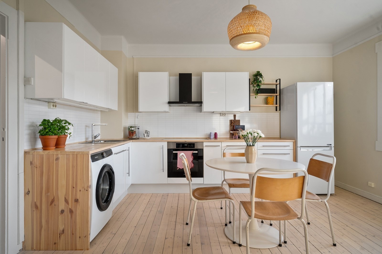 Pent, lyst kjøkken med rikelig oppbevaringsplass og flere soner for matlaging. Galleribilde