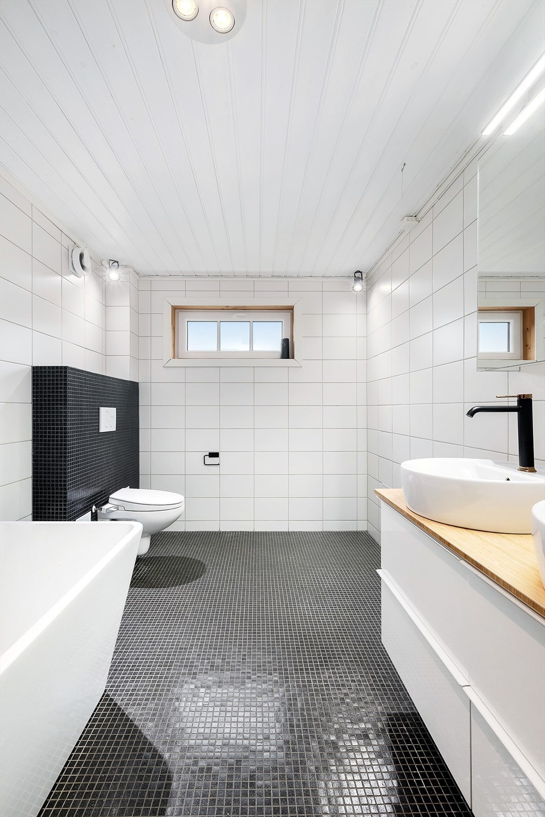 Stilrent bad med dusjhjørne, servant og toalett. Galleribilde