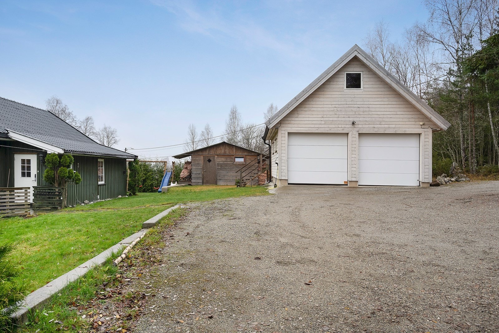 Innkjørsel og gårdsplass med plass til flere biler og lek. Galleribilde