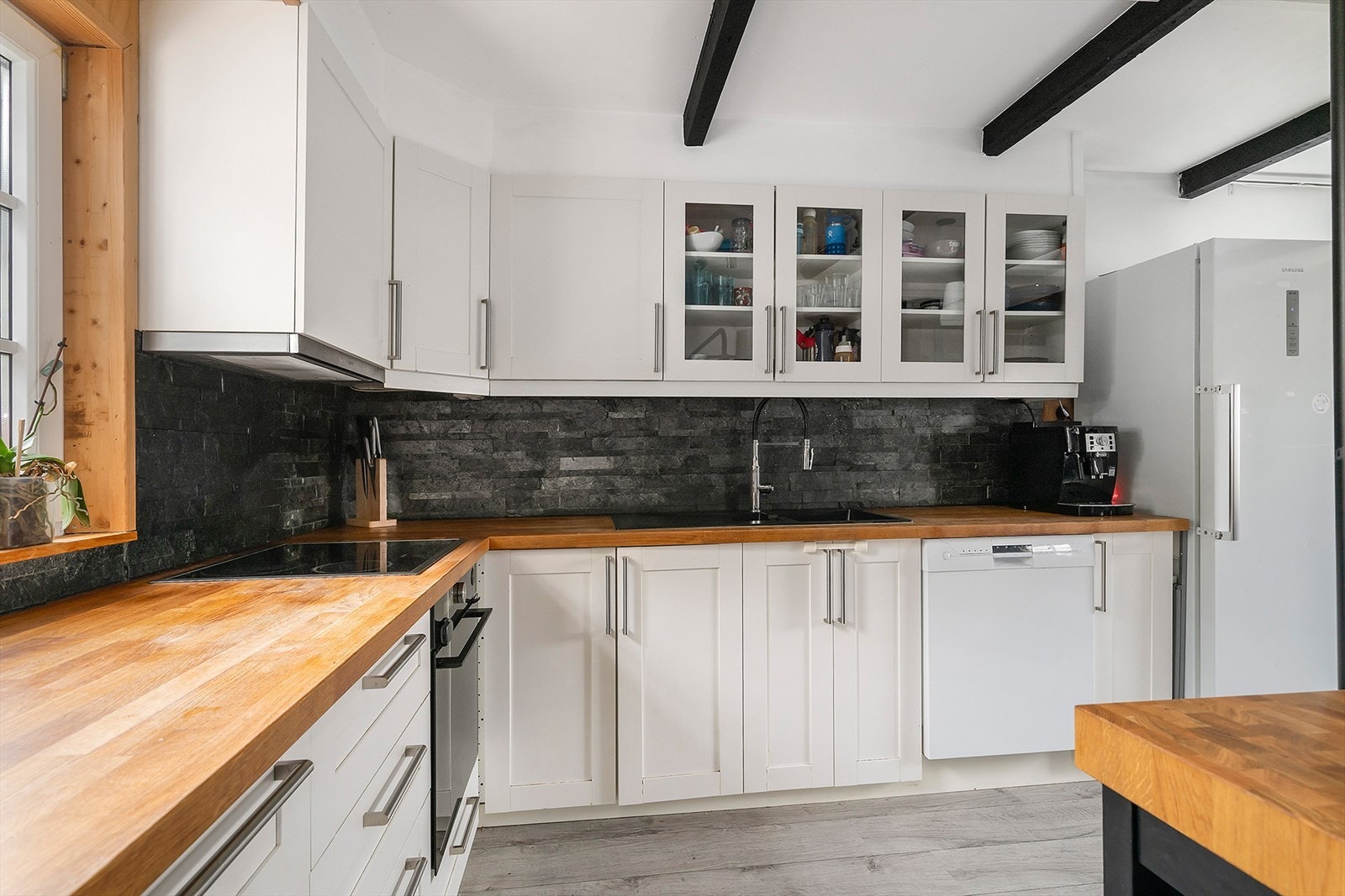 Pent kjøkken med profilerte fronter, godt benkeareal og vindu mot tunet. Galleribilde