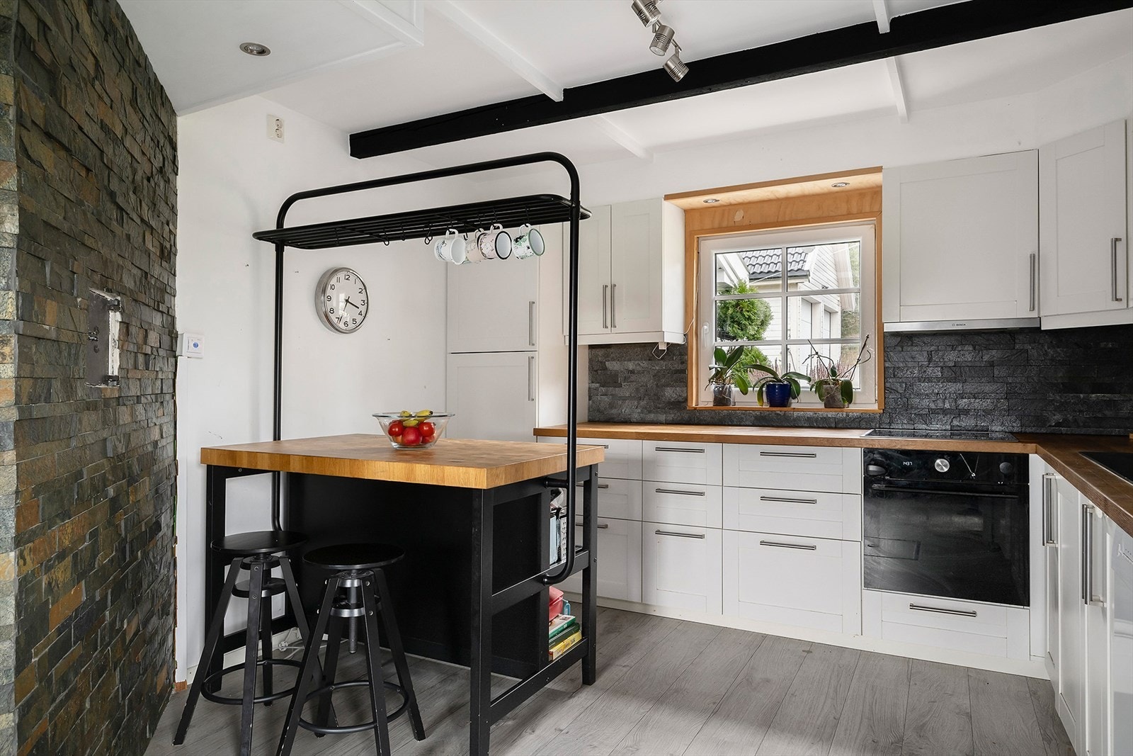 Kjøkken med spiseplass og naturlig sonedeling mot stue. Galleribilde