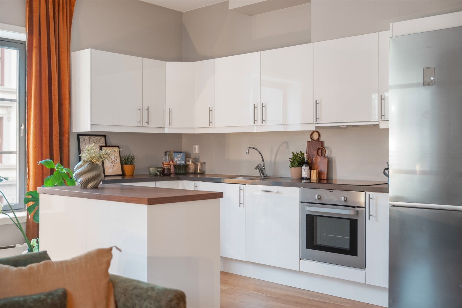 Kjøkkenet har en tidløs innredning med slette høyglansfronter, samt en praktisk kjøkkenøya på hjul som gir ekstra arbeidsplass og skaper en egen sone for matlaging. Galleribilde