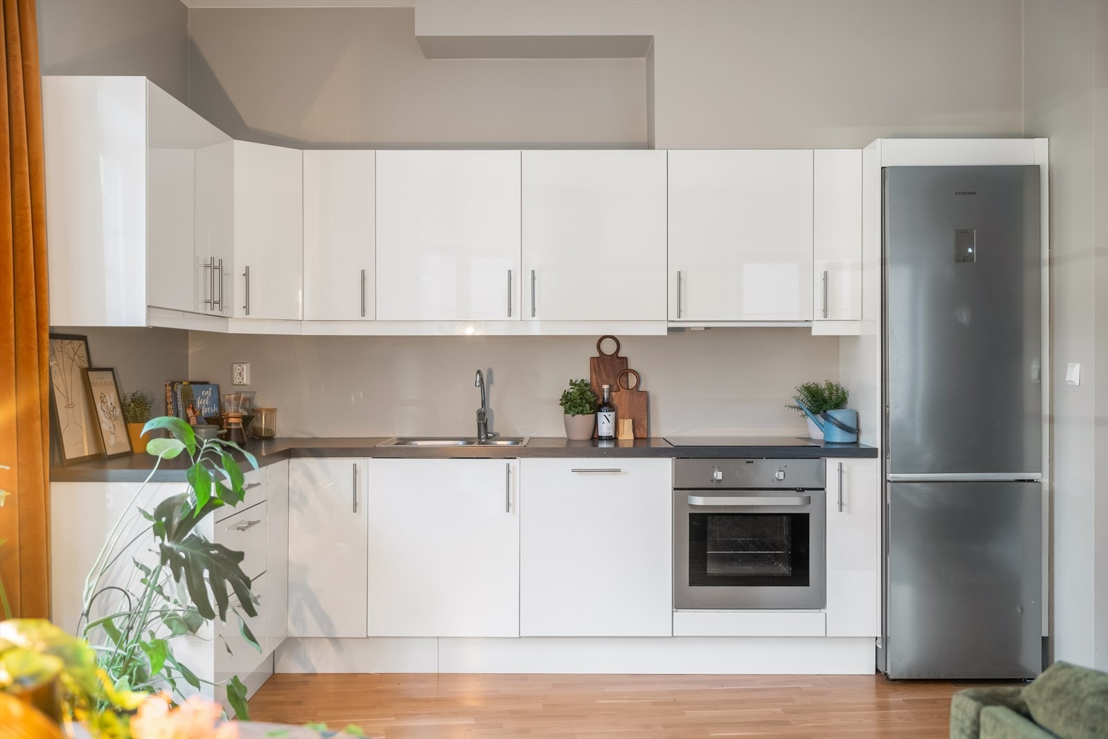 Kjøkkeninnredningen har glatte høyglansfronter og laminatbenkeplate, med 1 1/2 oppvaskkum, ventilator og integrerte hvitevarer som koketopp, stekeovn og oppvaskmaskin. Galleribilde