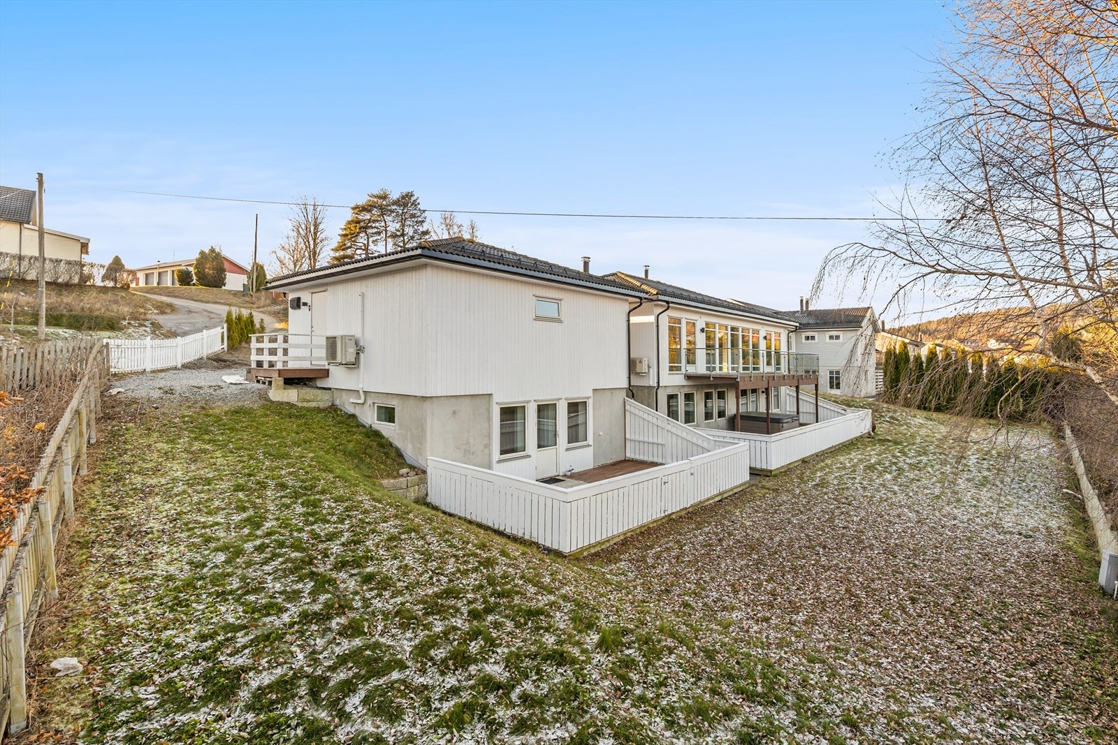 Enebolig over to plan med frittliggende dobbel garasje med hybel under. Gruset gårdsplass, trapper i terreng og fin hage. Galleribilde