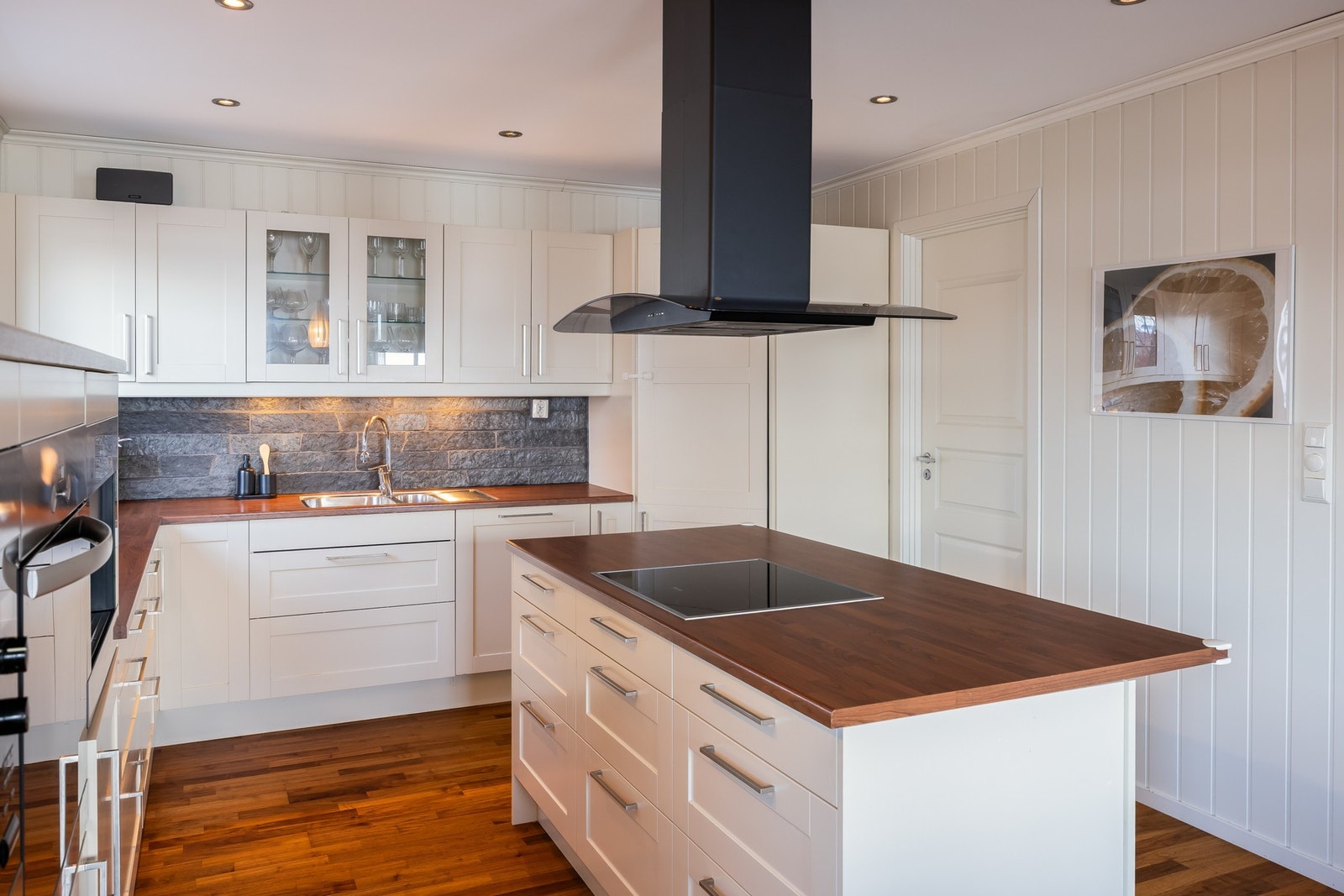 Innenfor kjøkkenet er en praktisk matbod utstyrt med hyller. Herfra har man utgang til baksiden av huset. Galleribilde