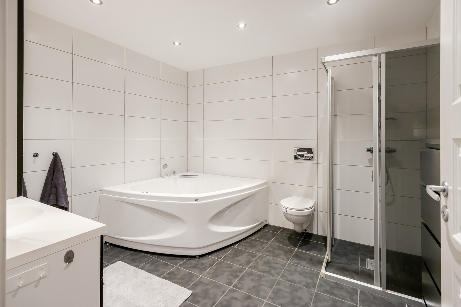 Hovedbadet på 9,6m² ligger i sokkel og fremstår som pent med flislagte vegger og gulv. Galleribilde