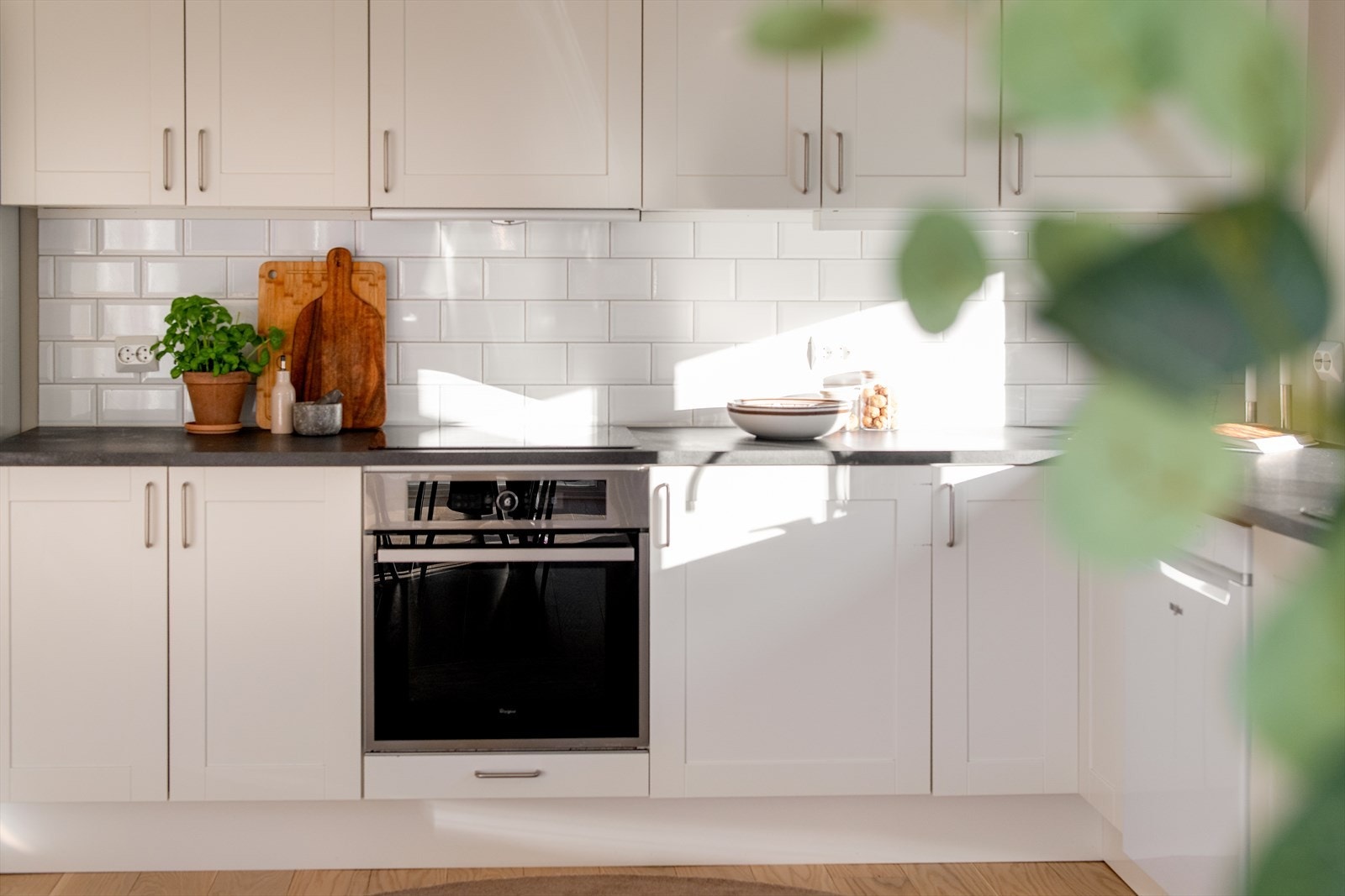 Lyst og pent kjøkkeninnredning med profilerte fronter og benkeplater av laminat. Galleribilde