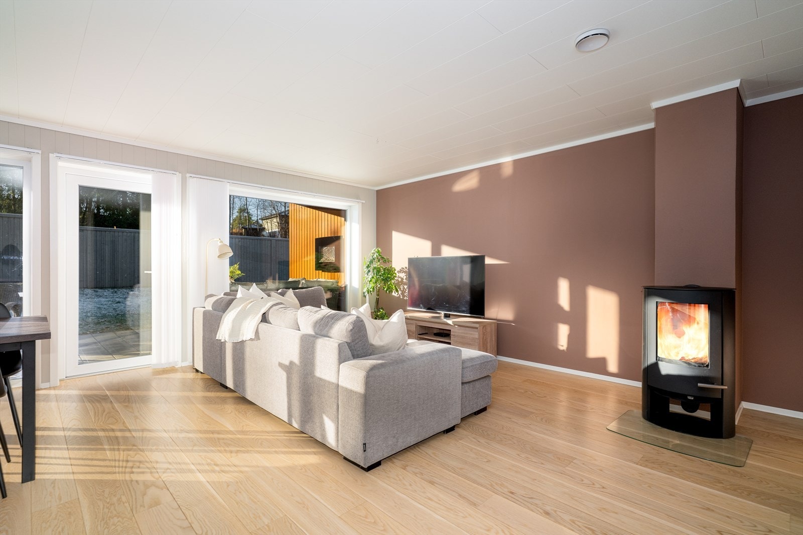 I stuen er det etablert en moderne vedovn med glassdører og glassplate. Galleribilde