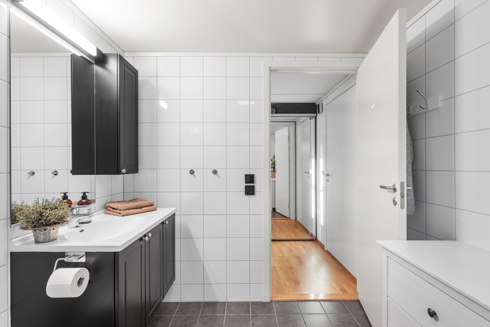 Utstyrt med dusjkabinett, gulvmontert wc, servantskap, servant og vannfordelerskap. Galleribilde