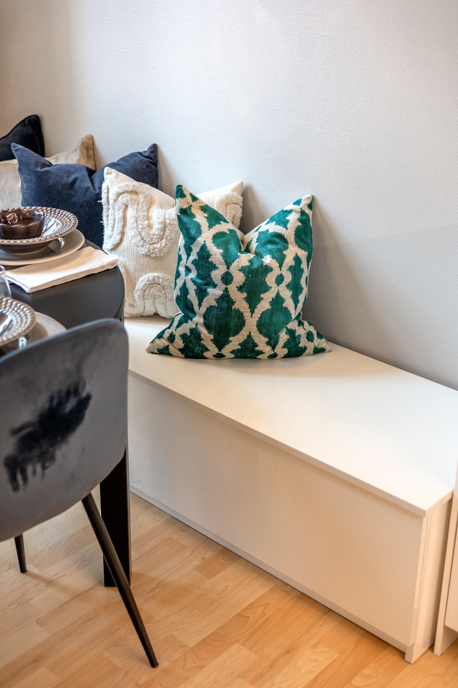 I forkant av kjøkkenet, mot vinduet, er det en praktisk sittebenk med lagring som medfølger handelen Galleribilde