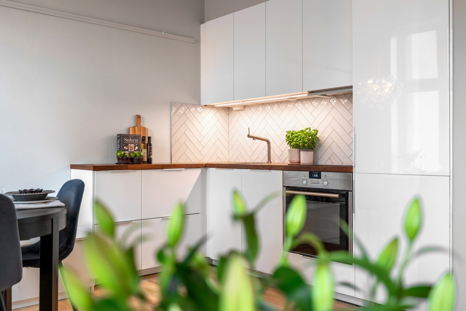 Kjøkkeninnredningen har glatte fronter og benkeplate i laminat med stålkum Galleribilde