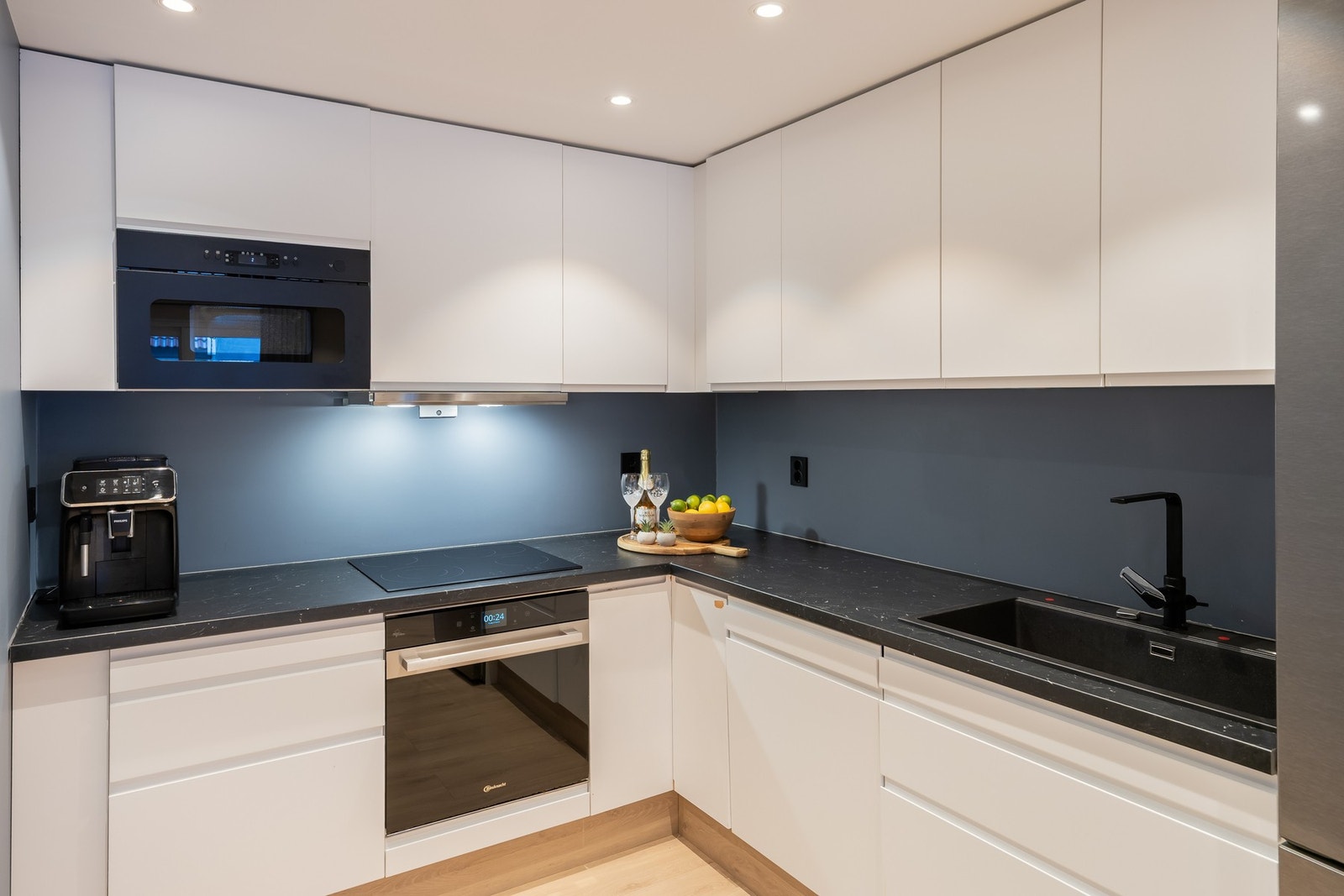 Moderne og tidløst kjøkken i praktisk L-form med rikelig med skap- og benkeplass. Galleribilde