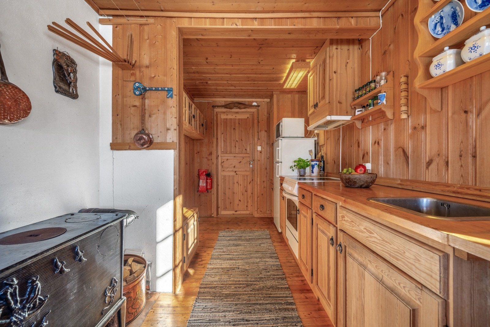 Kjøkkenet er romslig og har original kjøkkeninnredning fra byggeåret, laget i heltre furu. Her er det rikelig med benkeplass, perfekt for matlaging og koselig hytteliv. Galleribilde