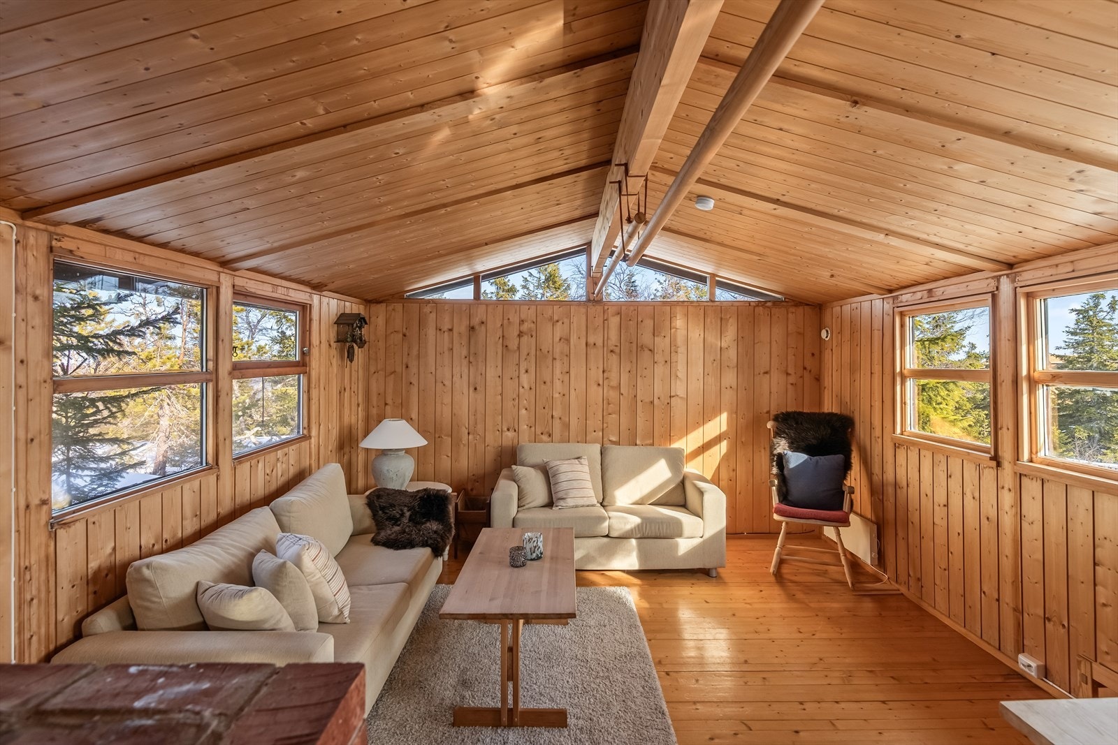 Stuen virker romslig og lys med høy takhøyde og rikelig med vinduer Galleribilde