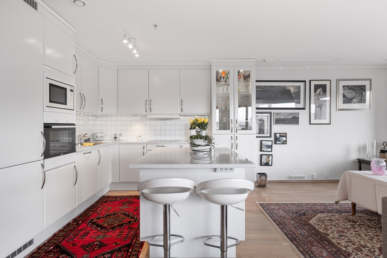 Kjøkkenet har innredning med hvite glatte fronter Galleribilde