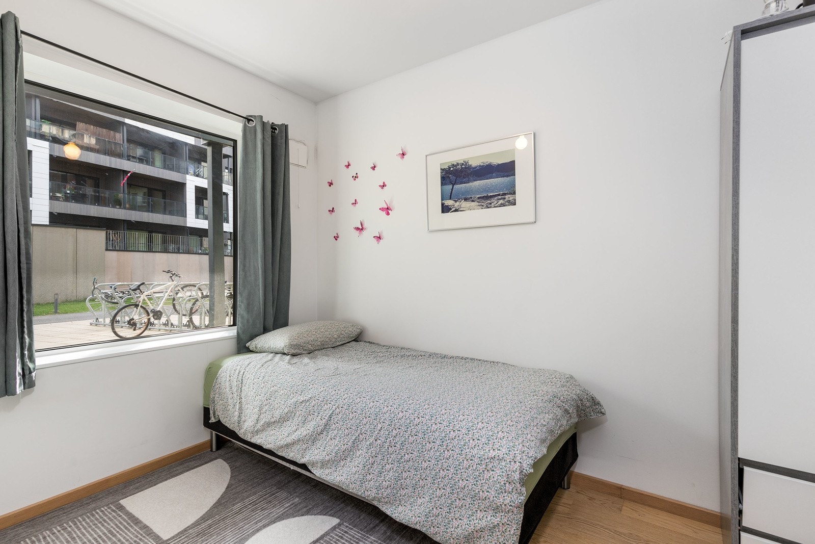 Soverom 2 har lysmalte veggflater, enstavs hvitpigmentert parkett på gulv, samt garderobeskap. Galleribilde