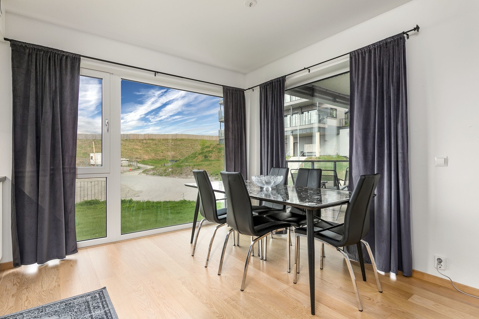 God plass til et større spisebord i forkant av kjøkkenet. De store vinduene sørger for rikelig med innslipp av naturlig lys i boligen. Galleribilde