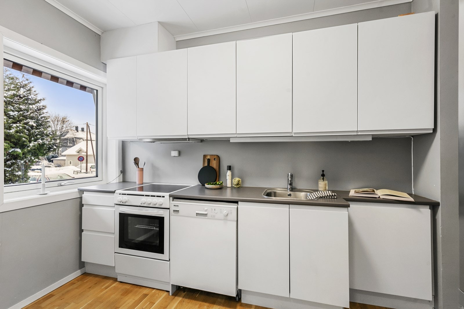 Kjøkkenet er i delvis åpen løsning til stuen. Innredningen har lyse, slette fronter og laminat benkeplater. Galleribilde