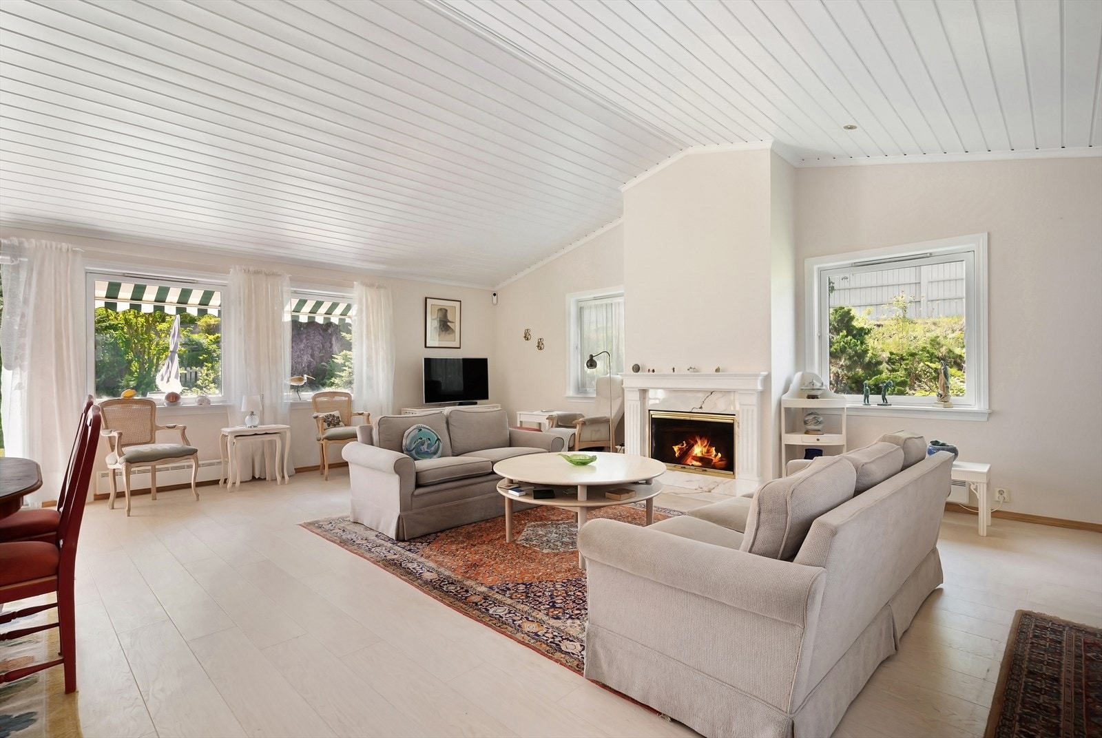 Stuen er et herlig rom med svært god takhøyde, mange vinduer og god plass. Peisen bidrar til lunhet og god stemning når den er i bruk. Galleribilde