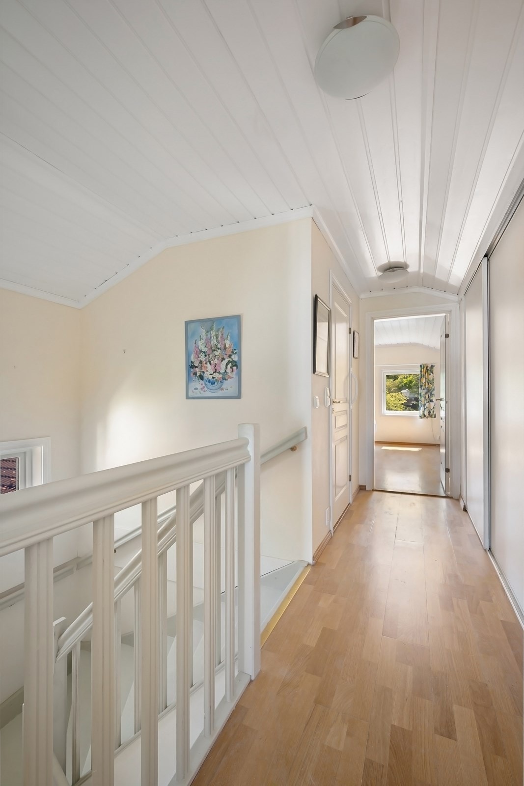 Trappen fra 1. etasje tar deg til en lys og luftig gang/trapperom - hvor man har utnyttet plassen langs den ene veggen til garderobe med skyvedører. Galleribilde