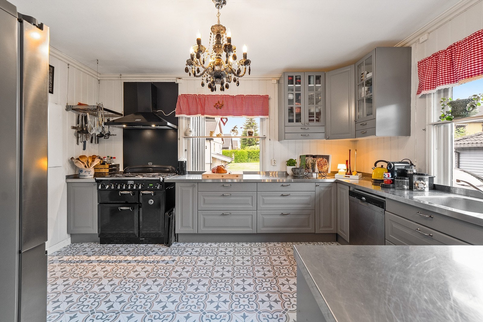 Innredningen er fra 2009 med profilerte fronter, det er frittstående gasskomfyr fra Falcon plassert i nisje, frittstående side by side kjøleskap med fryser samt dispenser, IKEA underskap med rustfri storkjøkken topper på alle benker Galleribilde