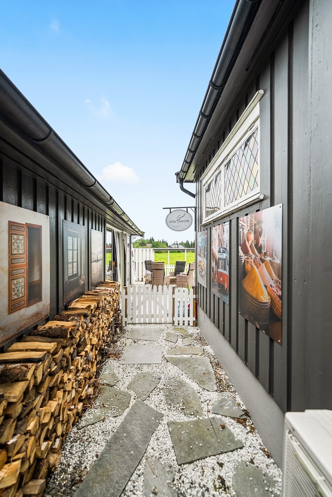 Hagegang mellom garasjen og boligen. Bildene som er fastmontert på fasadene kan medfølge Galleribilde