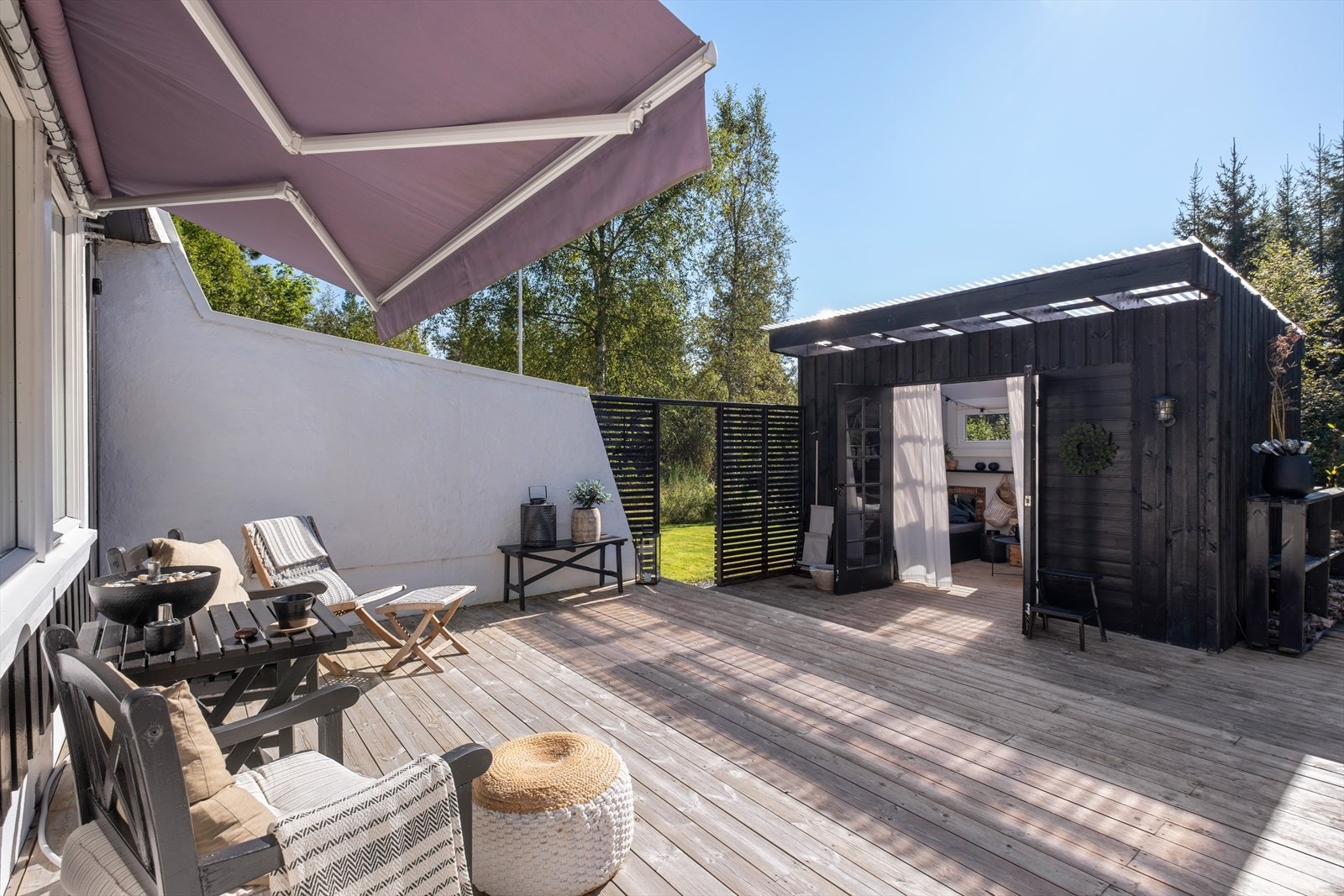 Stor terrasse med høy trivelsfaktor - det er montert markise på vegg Galleribilde