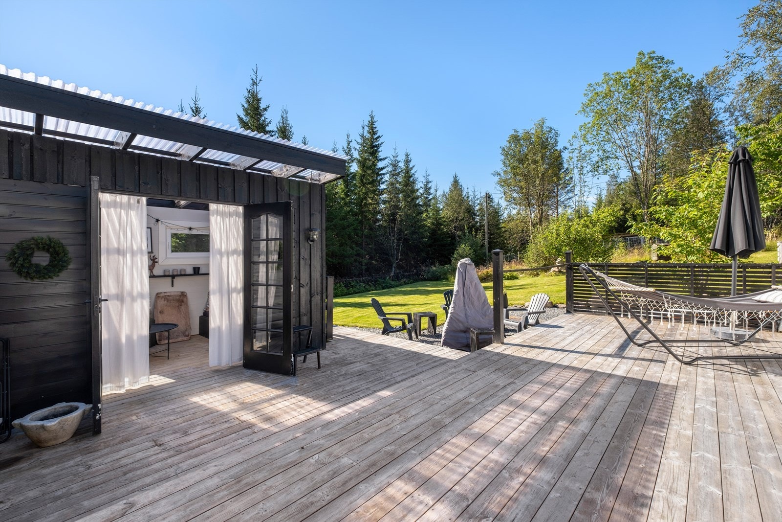 Videre fra terrassen har man inngang til en hagestue samt ut til hagen Galleribilde