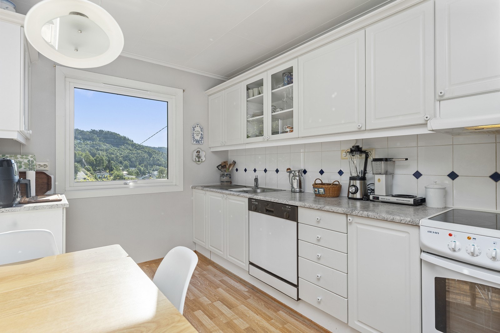 Kjøkkeninnredning med profilerte fronter og laminerte benkeplater. Galleribilde