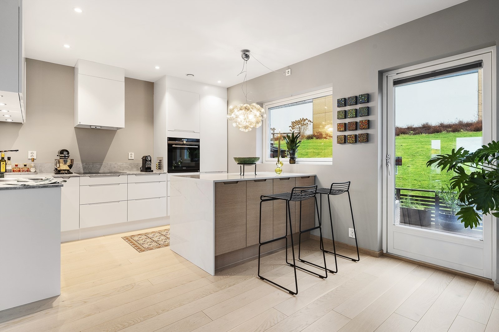 Innredningen har lyse, slette fronter med grepslister, kombinert med laminatbenkeplate og nedfelt kjøkkenkum. Galleribilde