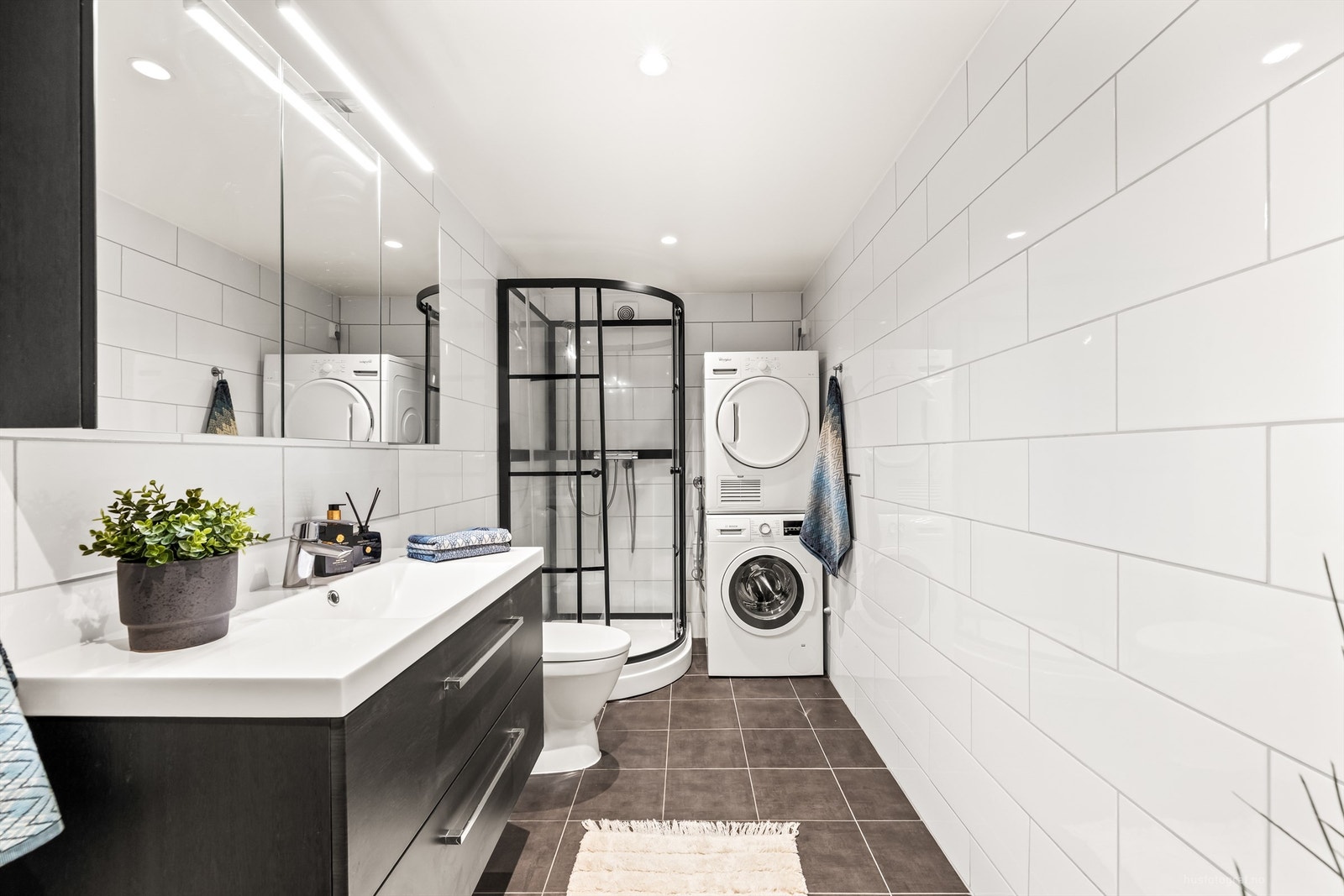 Delikat, flislagt bad fra 2019 med dusjkabinett og opplegg for vaskemaskin samt tørketrommel. Galleribilde