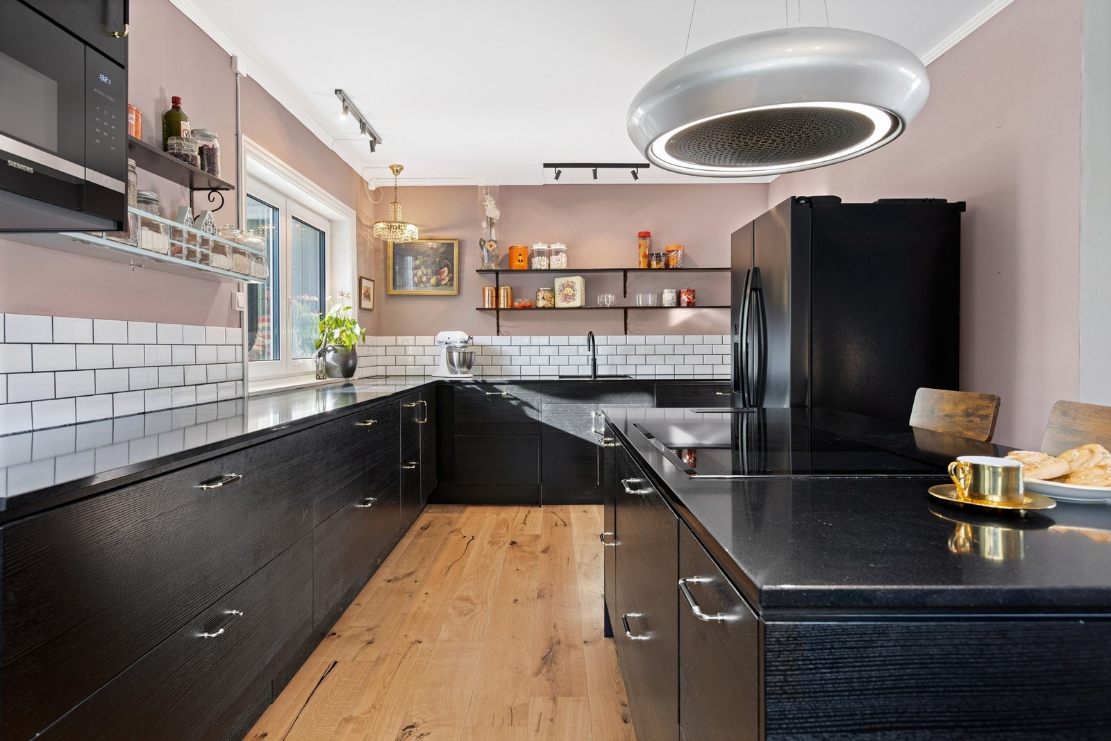 Romslig kjøkkeninnredning med integrert stekeovn, oppvaskmaskin, platetopp, mikro, kaffemaskin samt benkeplate av stein/kompositt Galleribilde