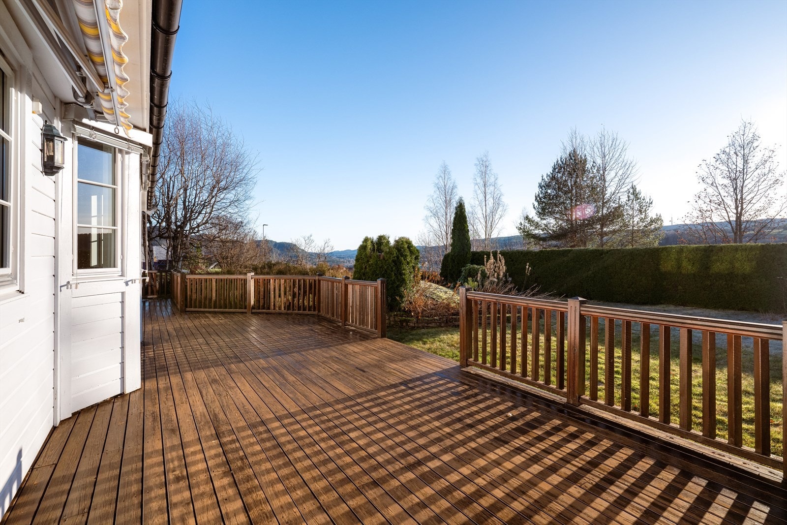 Tomten er meget pent opparbeidet med plen, variert beplantning og støttemur, samt store terrasser med rekkverk og gode solforhold. Galleribilde