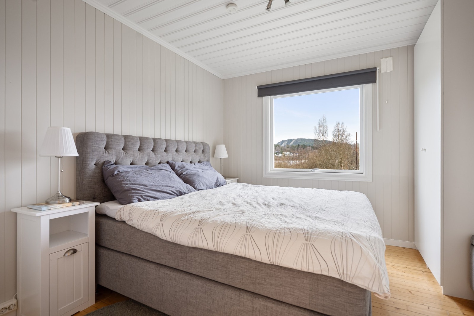 Romslig hovedsoverom med god plass til dobbeltseng og garderobeløsning. Det store vinduet gir et behagelig lysinnslipp og fin utsikt over nærområdet, noe som bidrar til en rolig og behagelig romfølelse. Galleribilde
