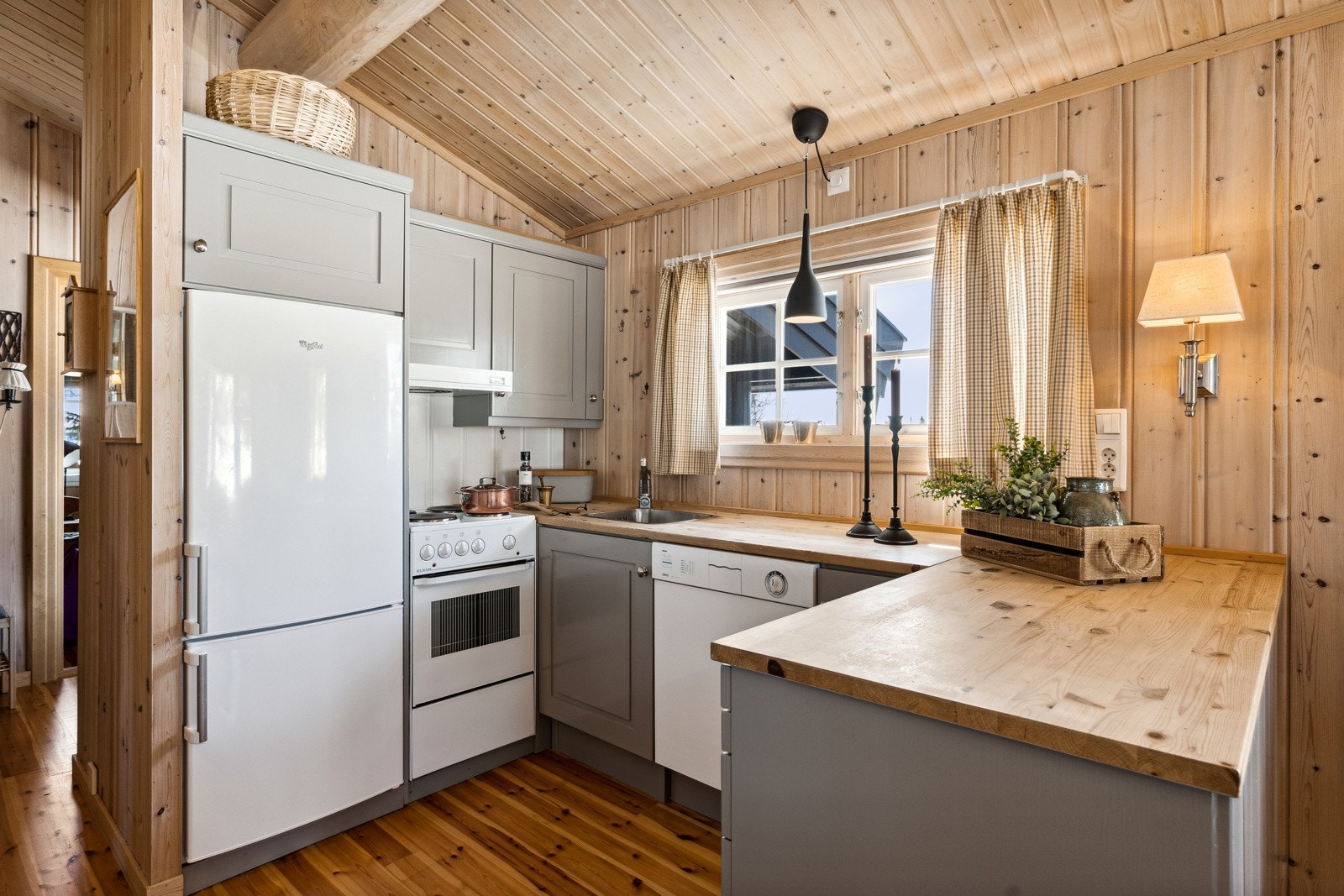 Videre inn i hytta finner du et praktisk utformet kjøkken, i åpen løsning mot spisestua og stua. Kjøkkenet er innredet med laminerte skrog og profilerte fronter, malt i en lun greige farge. Galleribilde